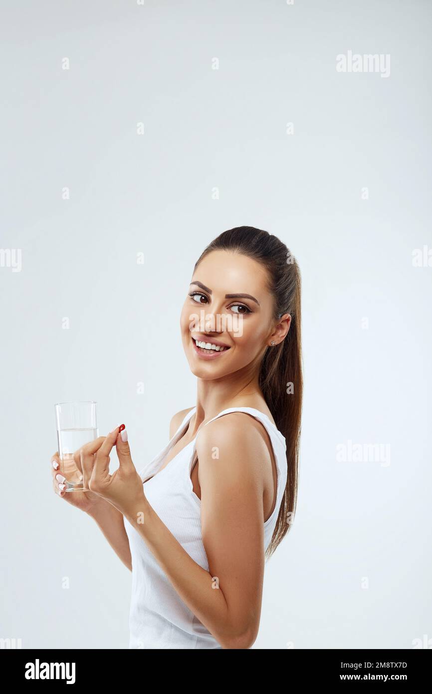 Portrait of beautiful woman holding glass of fresh wate and vitamin,pill Stock Photo