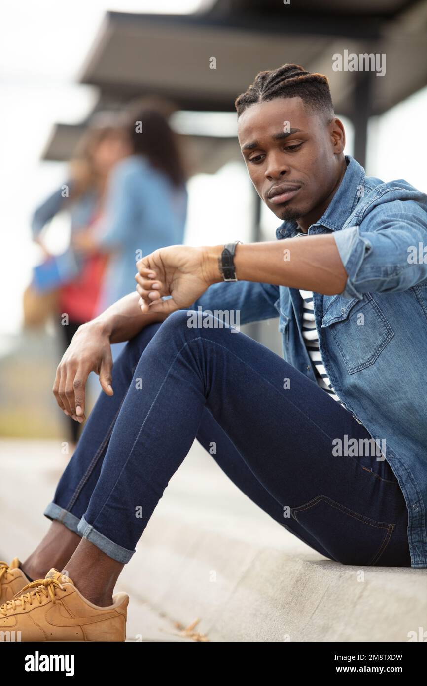 young man checking the time on wristwatch at rail station Stock Photo ...