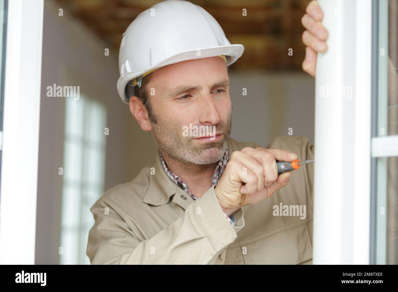 person tightening a screw with a screwdriver Stock Photo Alamy