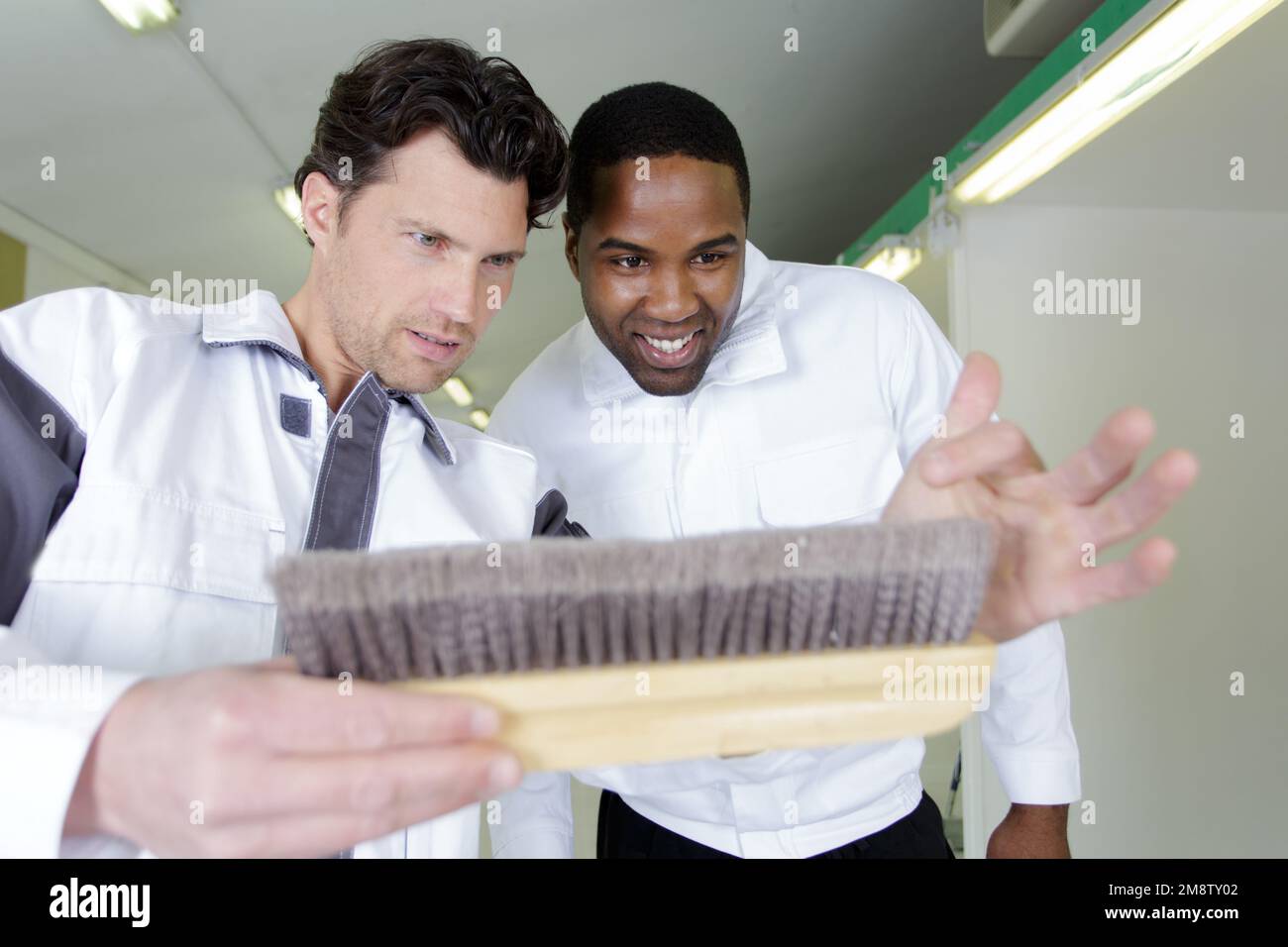 apprentice learning how to paint with a thick brush Stock Photo