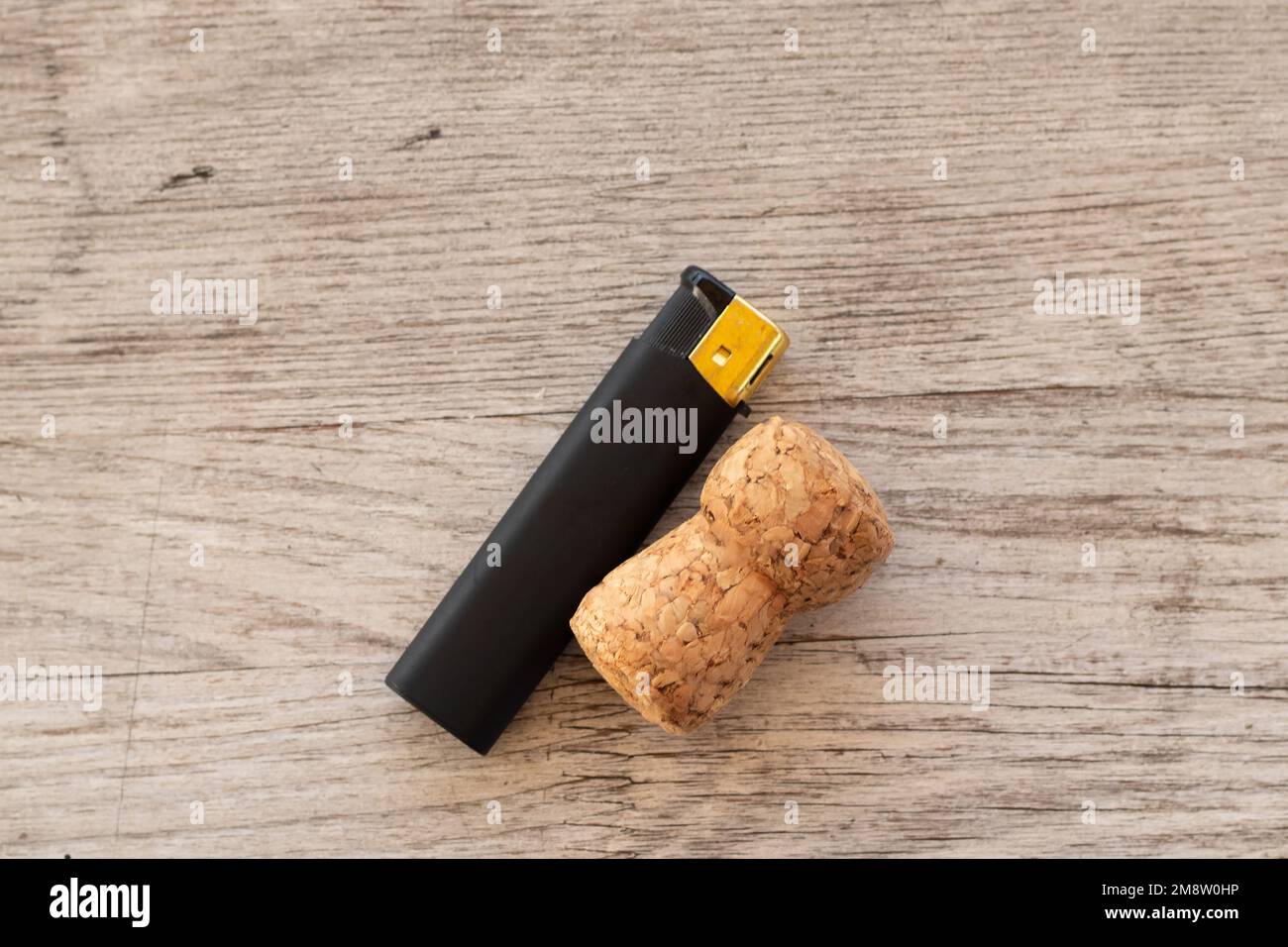 lighter and wine cap on a wooden table Stock Photo