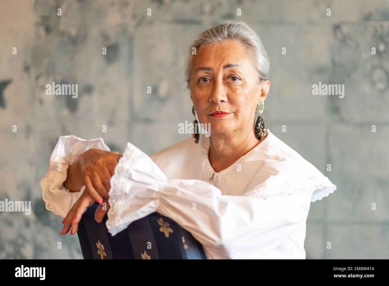 Unusual studio portrait of a lady with raised hair and large earrings Stock Photo