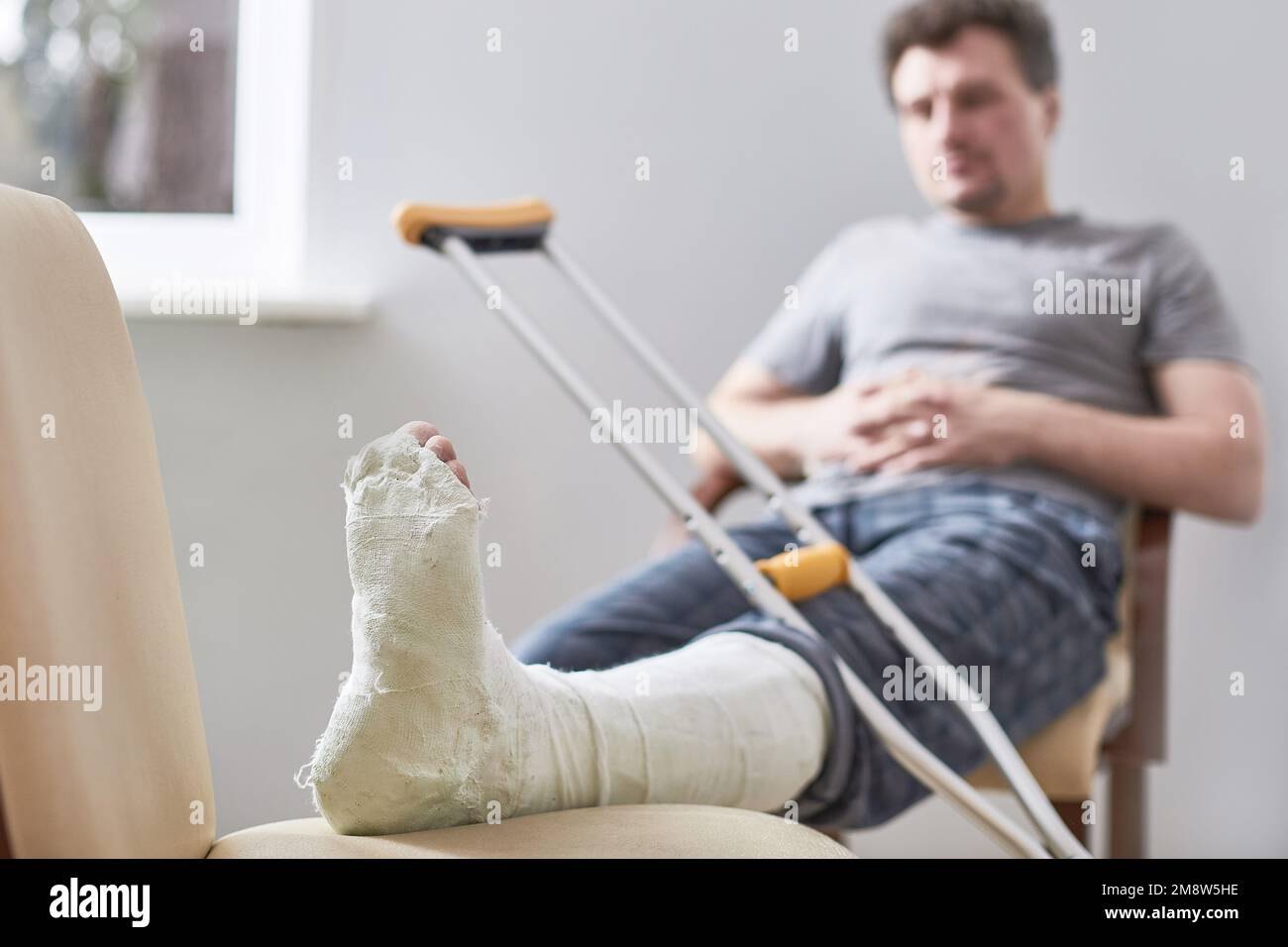Close up of a young man's Plaster leg cast and after a running injury or fall Stock Photo