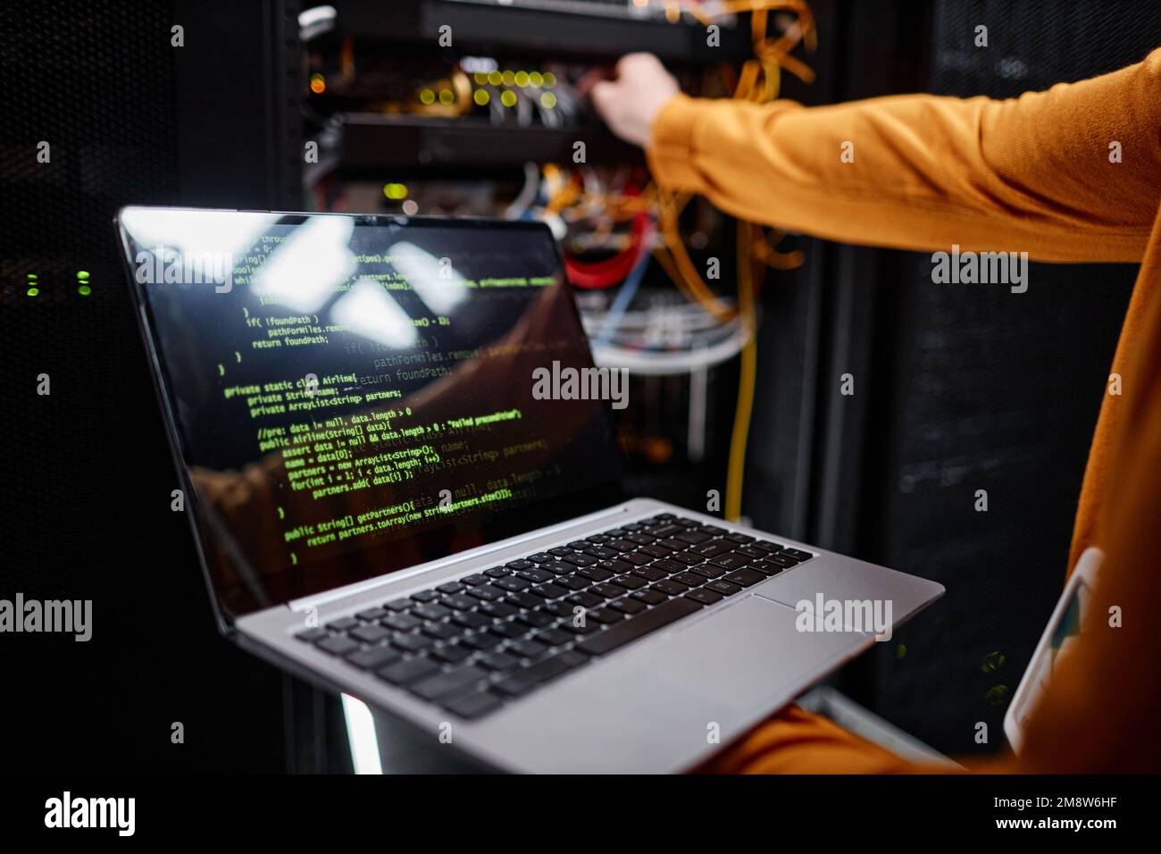 Closeup of IT engineer using laptop while setting up network in server room, copy space Stock Photo