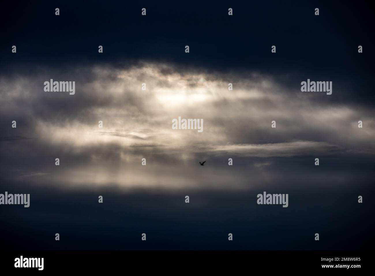 Dramatic, dark storm clouds in sky - rays of light streaming through Stock Photo
