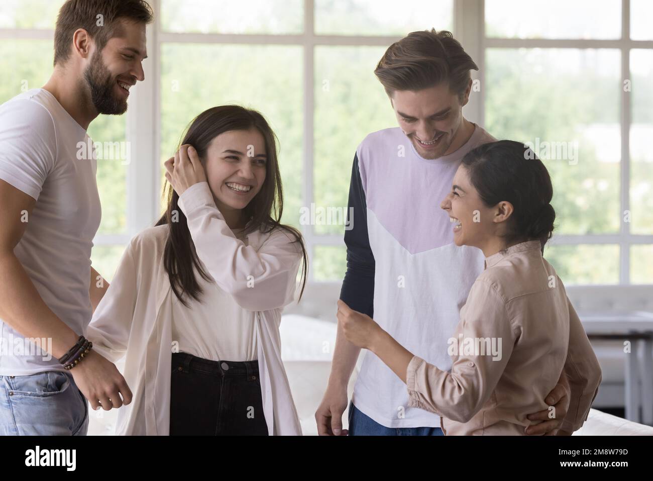 Diverse group of friends standing in cafe interior, chatting Stock Photo