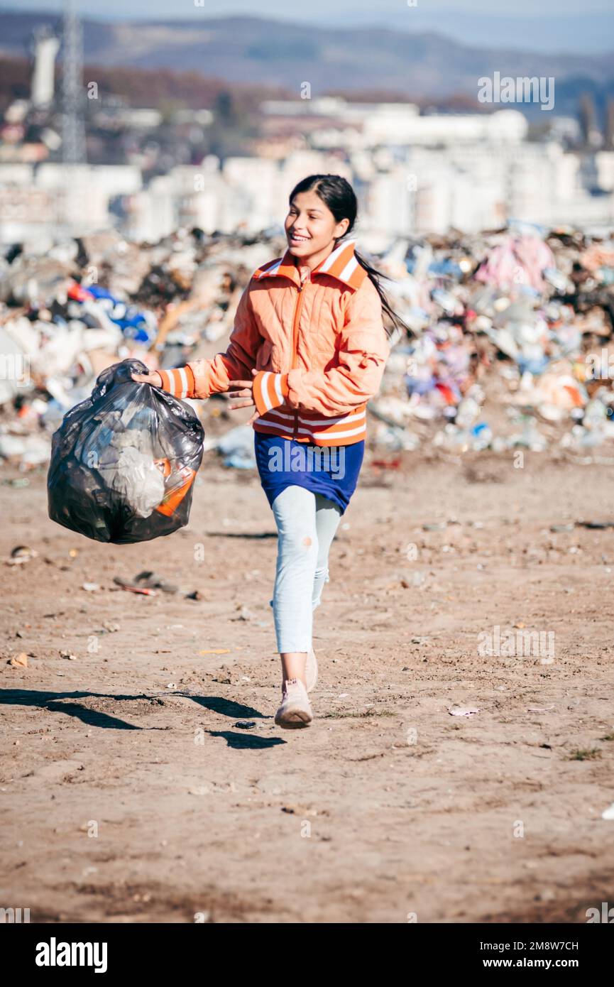 A vertical shot of the poor teenage girl holding a trash bag in a Romanian hellhole Stock Photo