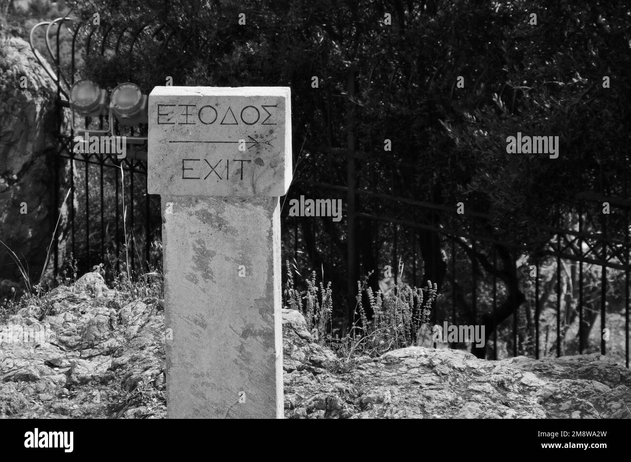 Sign pointing to the exit from the archaeological site of Acropolis in Athens, Greece. Black and white. Stock Photo