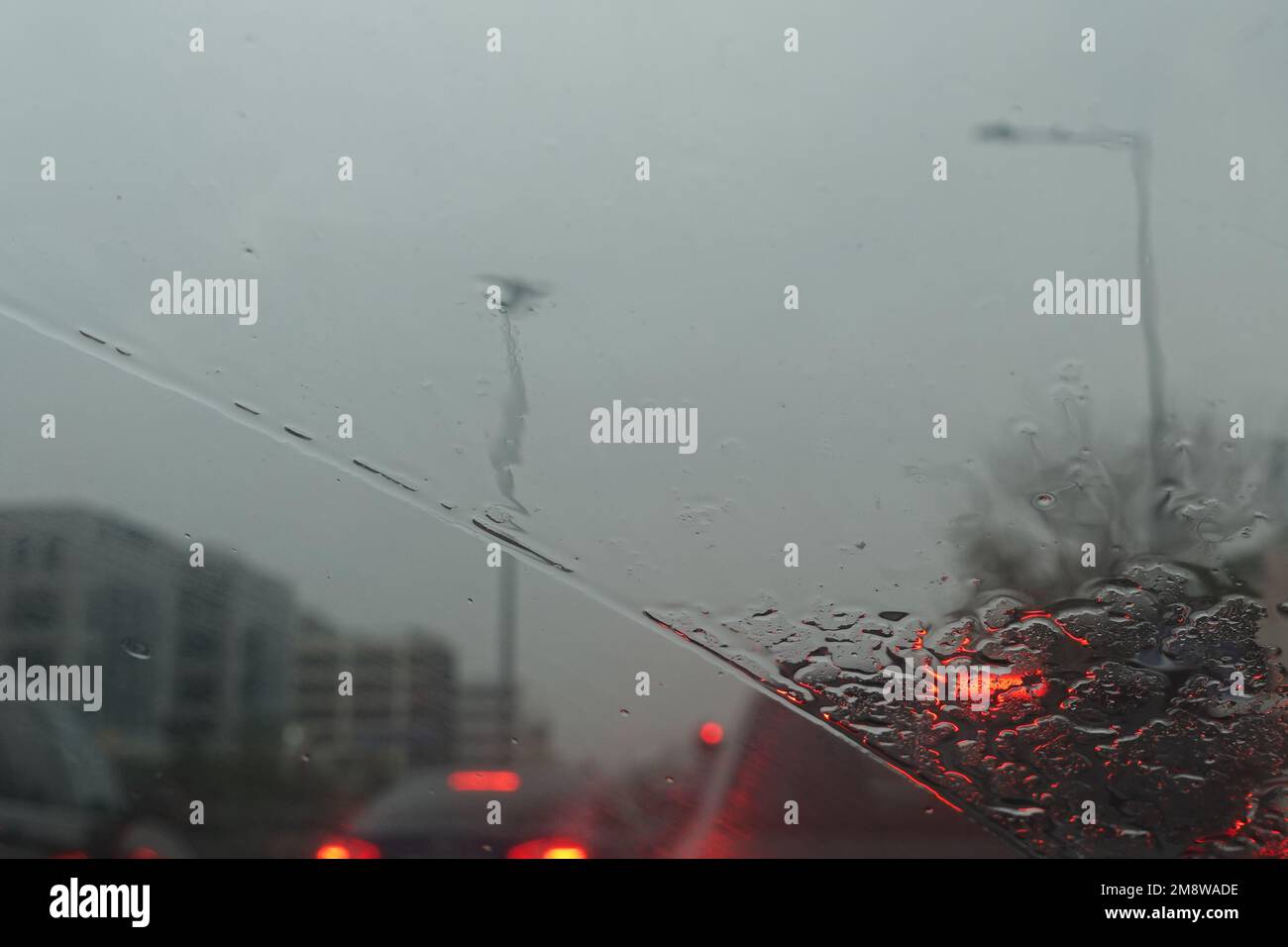 Traffic through car windscreen on a rainy day. Abstract blur. Stock Photo