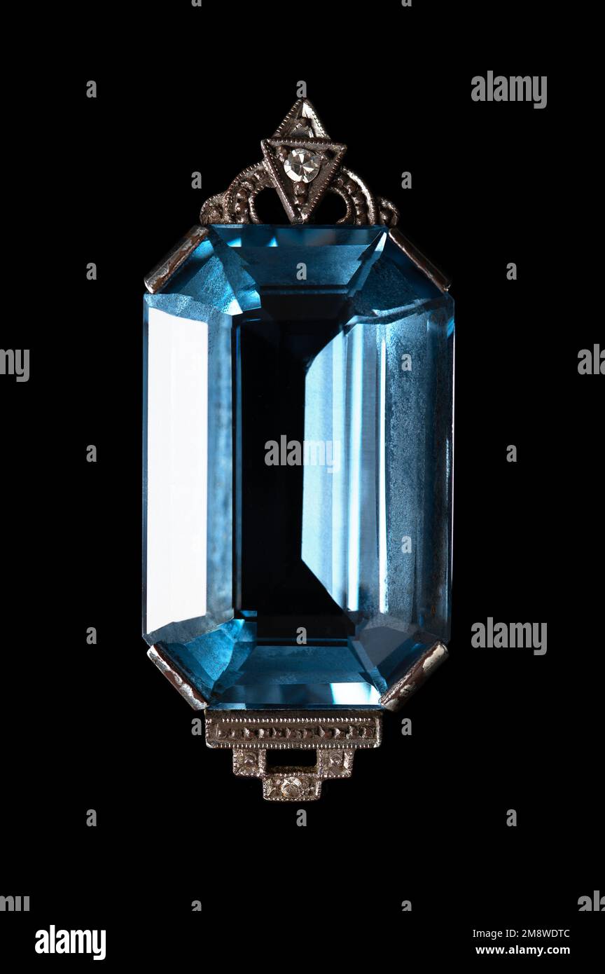 Emerald cut aquamarine, in octagon shape, set in a detailed Art Deco style silver necklace pendant, with two small diamonds. Close-up, isolated. Stock Photo