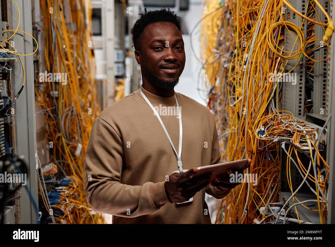 Waist up portrait of black man as system administrator standing in Waist up portrait of black man as system administrator standing in