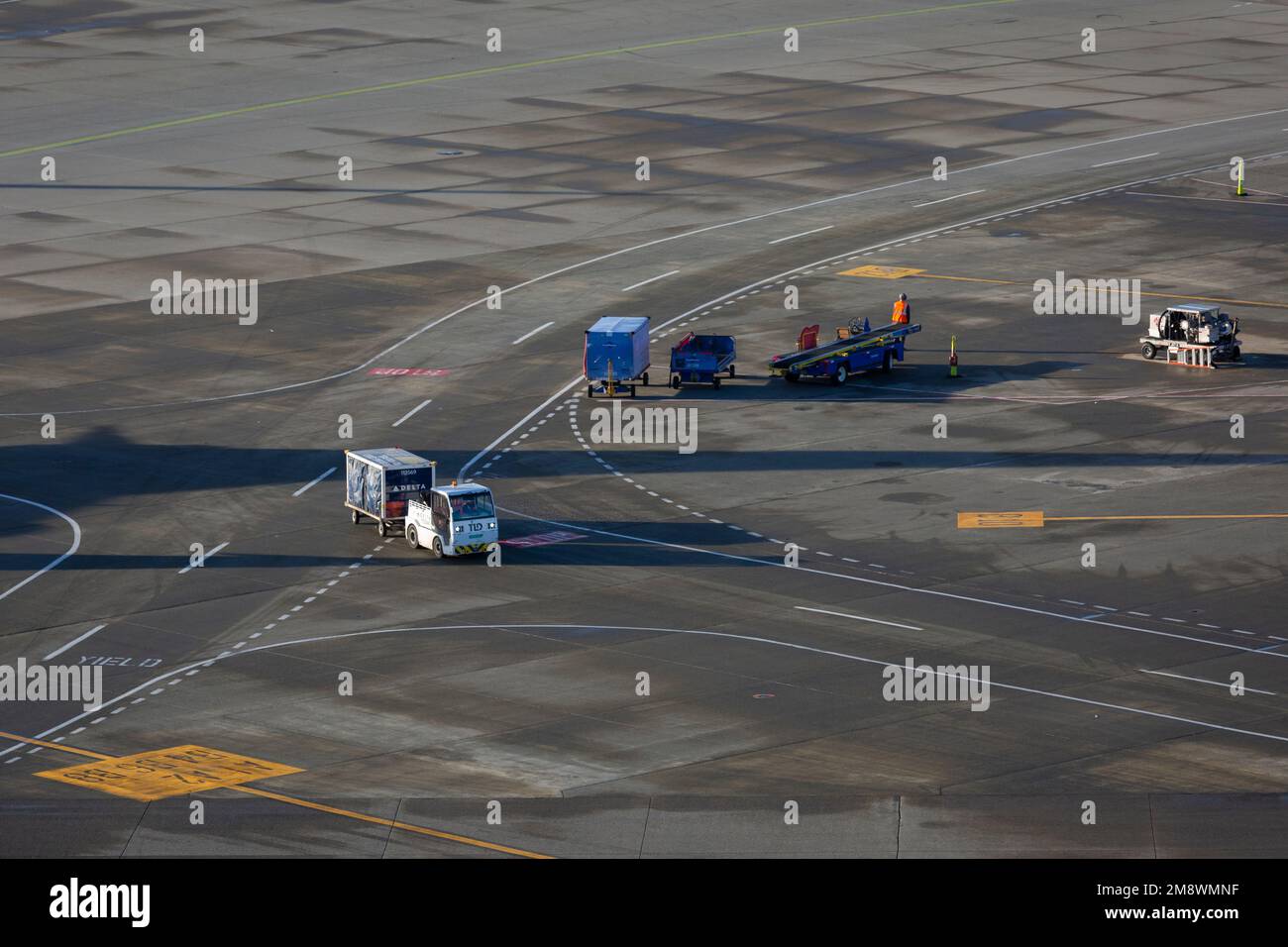 Baggage handlers move a baggage cart on the south ramp at Seattle