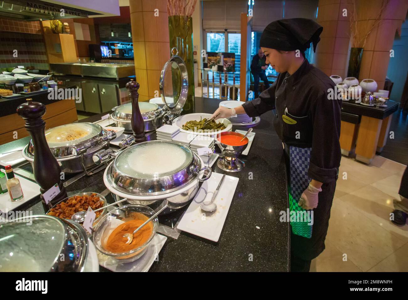 01-20-2015 Istanbul , Turkey. An employee of the food hall is improving something in the place for self-serving food according to the buffet system in Stock Photo