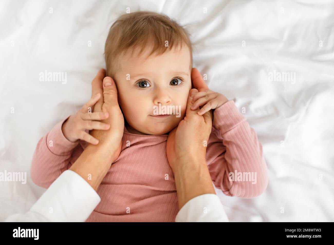 Mother care. Loving mommy touching her adorable baby girl, caring mom