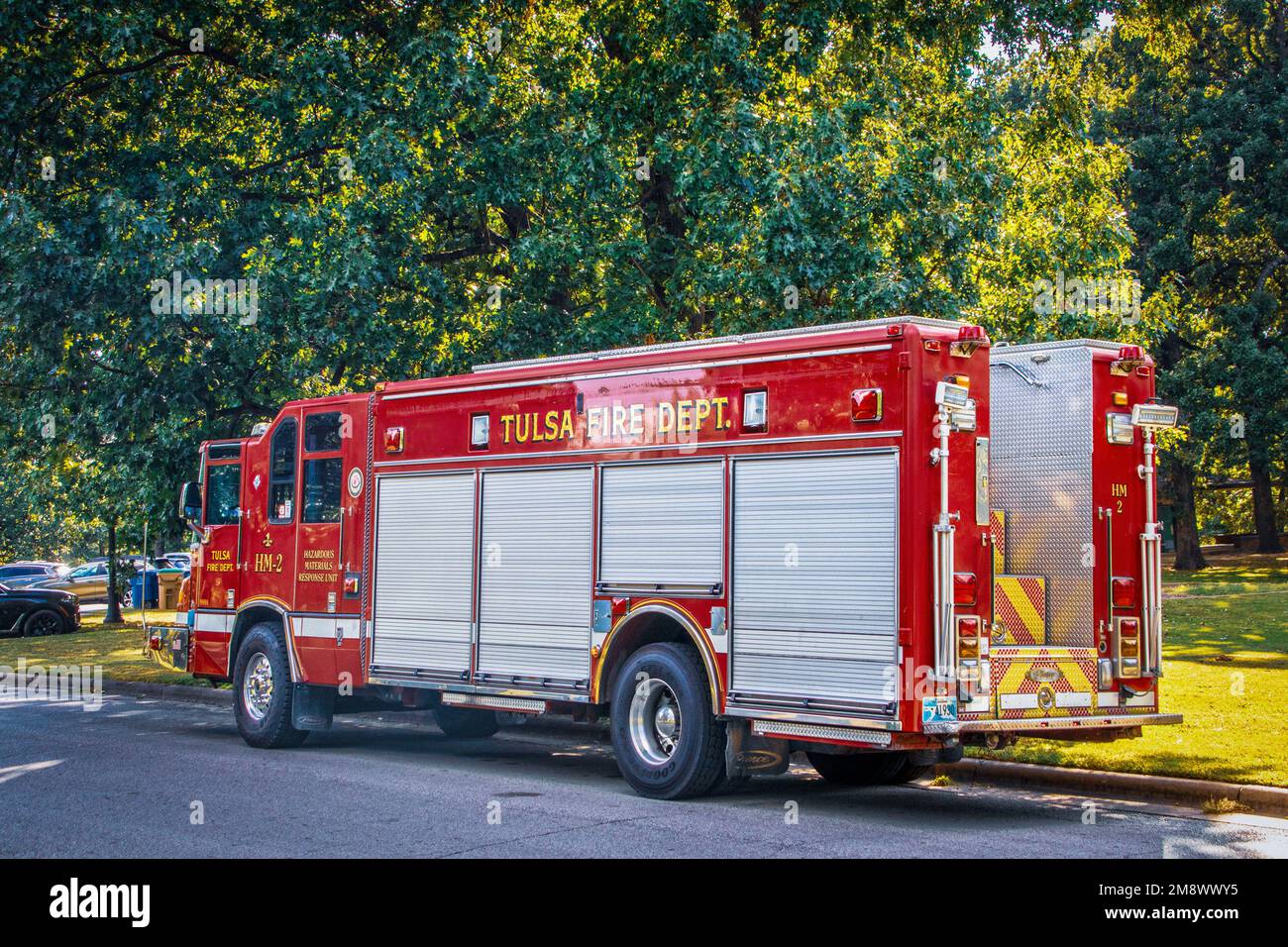 2022 09 17- Tulsa USA - Tulsa Fire Department Hazard Materials Response Unit Truck parked by curb in leafy park - Red with sliding doors on side and m Stock Photo