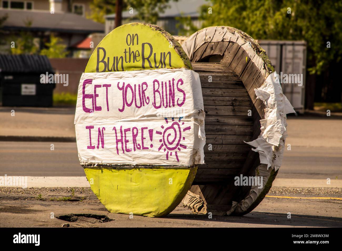 Fairbanks Alaska USA 2022-06-21 Sign created by plastic stapled onto large wooden cable spool-Drum Roller for food truck - Get your buns in here-Bun o Stock Photo