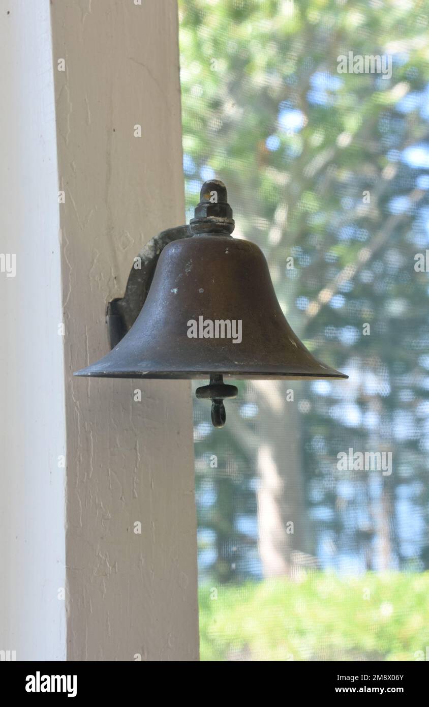 Fantastic metal brass bell hanging on a porch ready to be rung for ...