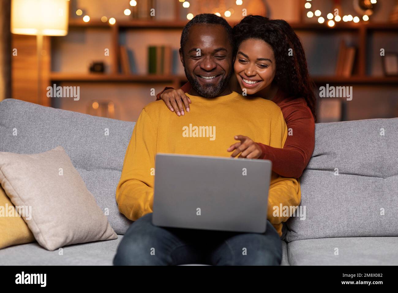 Married black couple using laptop at cozy winter evening Stock Photo