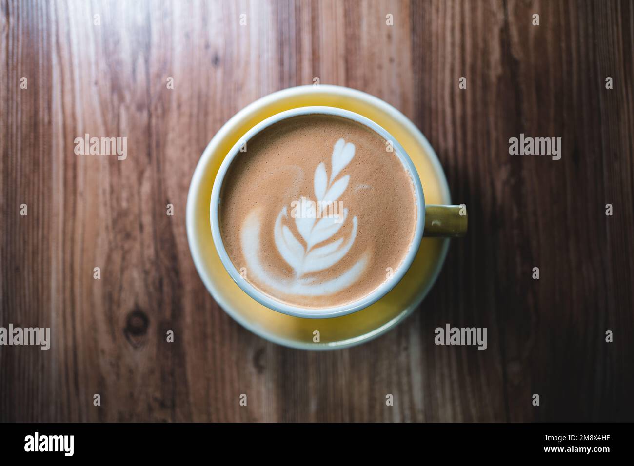 https://c8.alamy.com/comp/2M8X4HF/fresh-tasty-cappuccino-or-latte-coffee-with-milky-foam-on-wooden-table-in-cafe-2M8X4HF.jpg