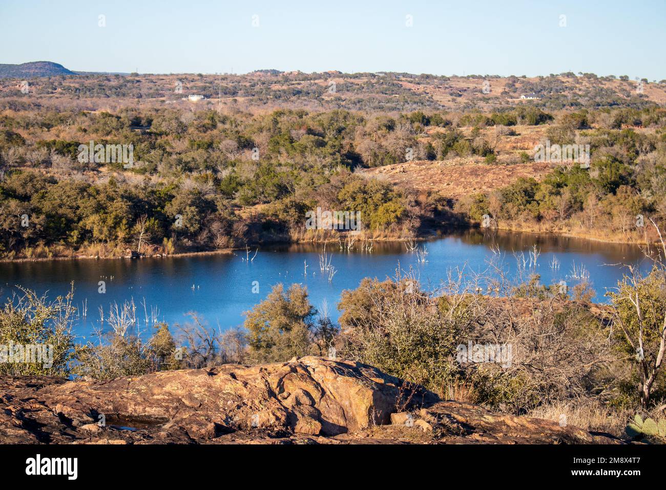 Texas Hill Country hiking trail with a view of Inks Lake. The golden