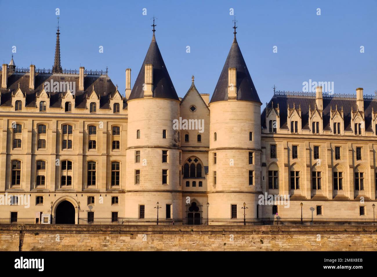 Paris: Conciergerie palais and Palace of Justice glowing gold soon after sunrise on the Ile de la Cite, Paris, France Stock Photo