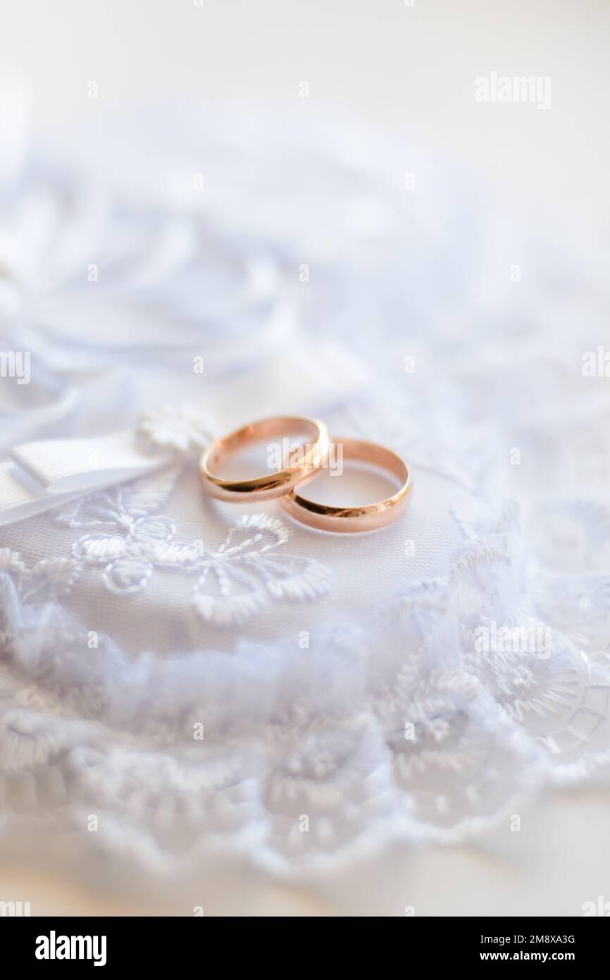 pair of gold wedding traditional rings on a white lace cushion on marriage registration Stock Photo