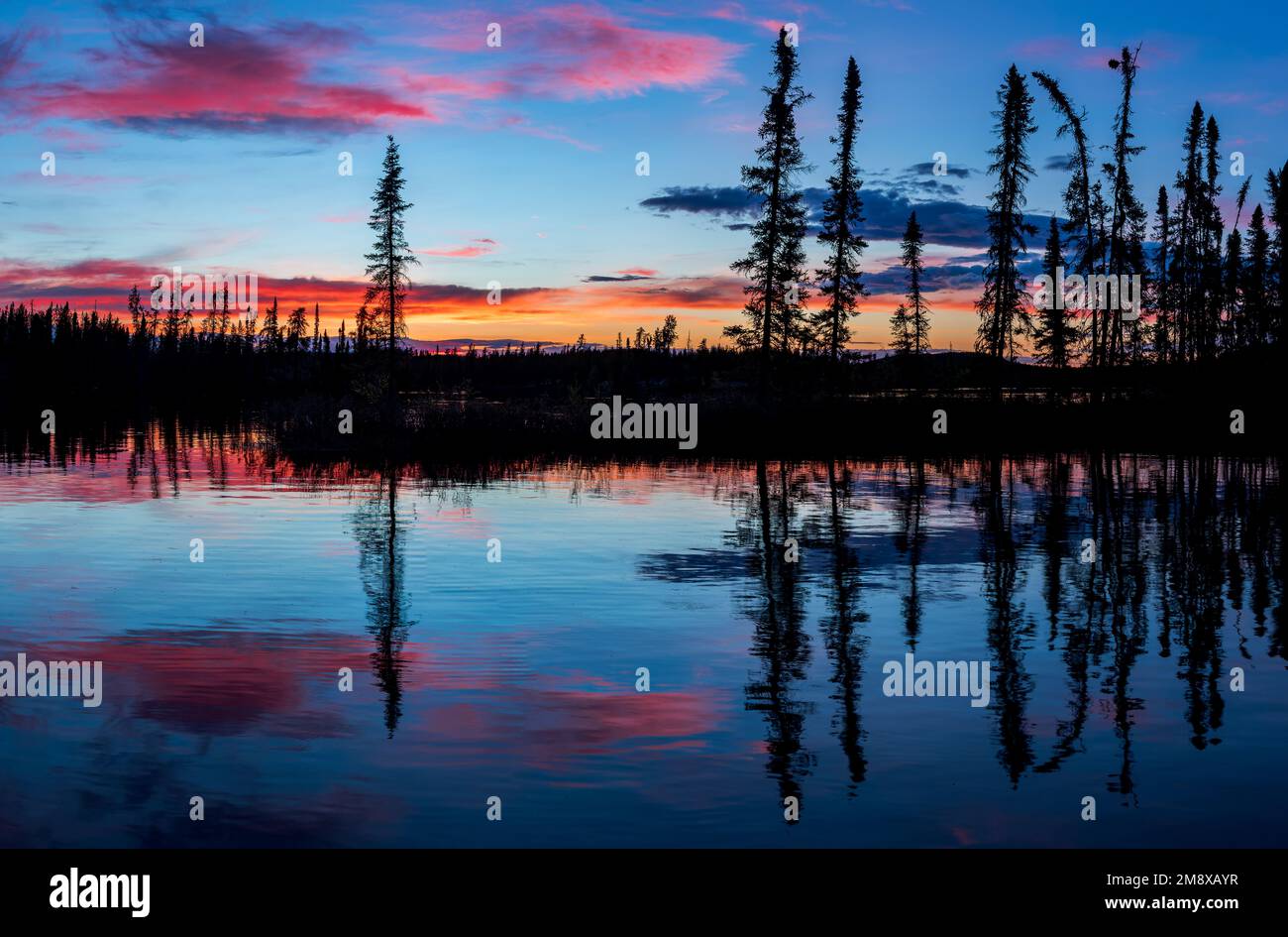 A sunset is reflected off calm Saskatchewan waters. Stock Photo