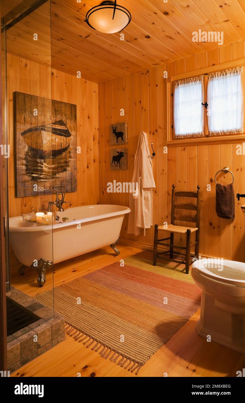 Claw foot bathtub, antique wooden high back chair and toilet in main