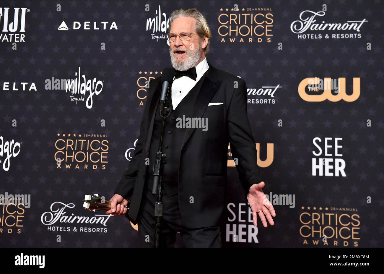 Jeff Bridges poses with the lifetime achievement award in the press