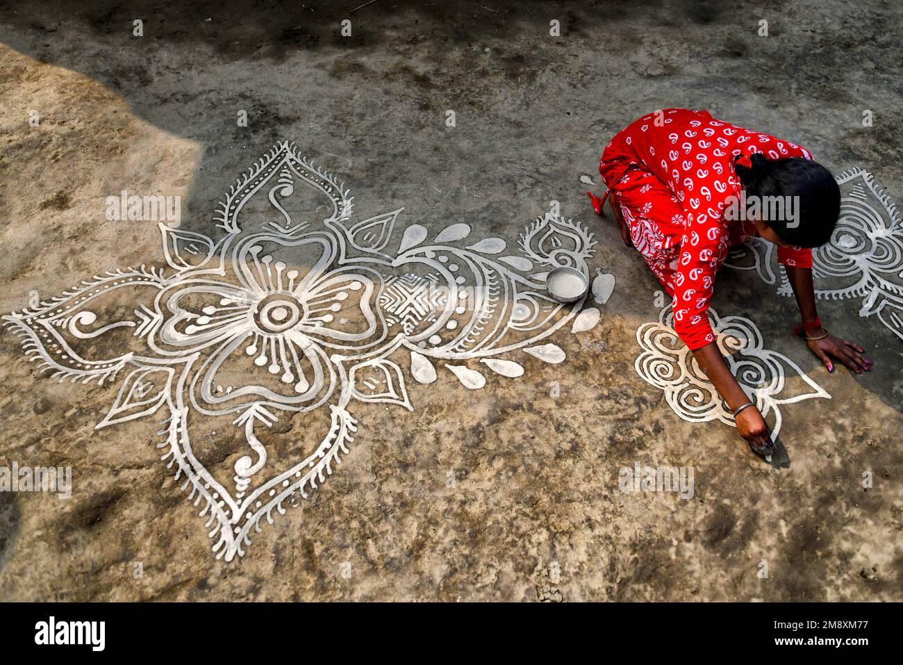 A Woman Seen Making Decorative Alpona During The Makar Sankranti which a-woman-seen-making-decorative-alpona-during-the-makar-sankranti-which