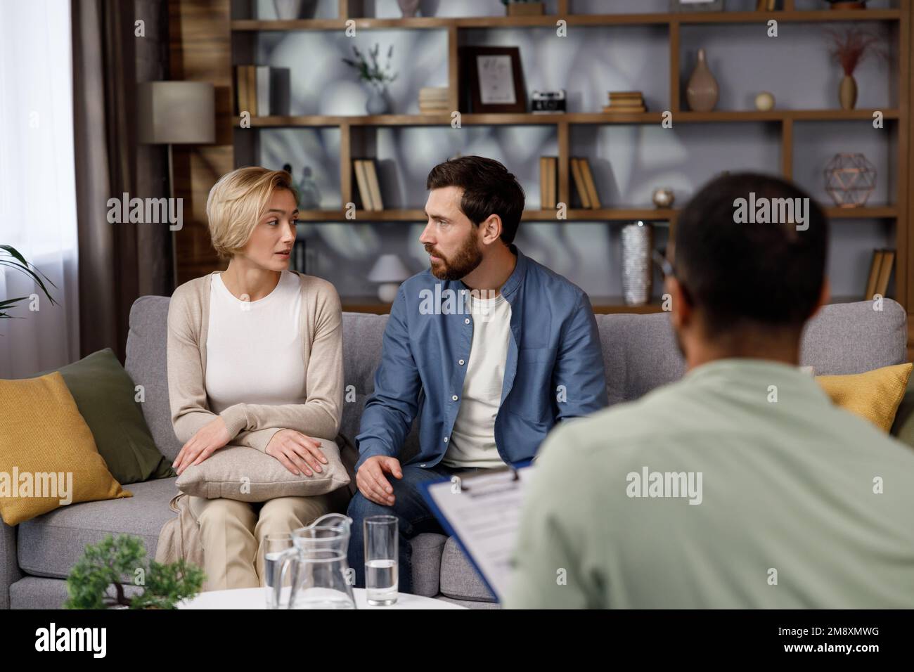 A visit to a family psychologist for a married couple. An African-American psychologist doctor consults an unhappy married couple. Relationship Stock Photo
