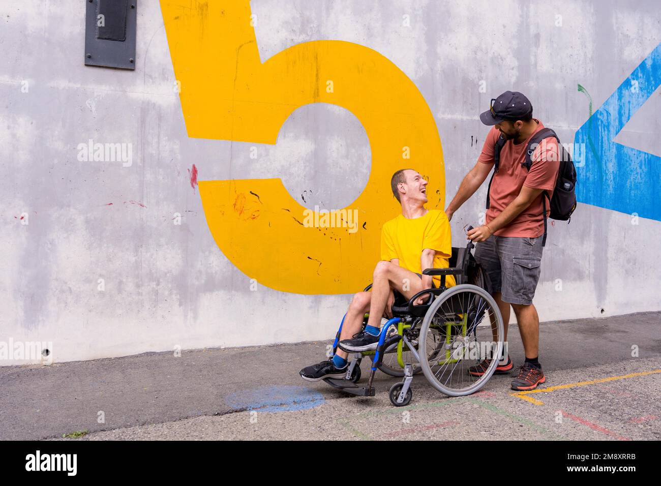 Disabled person in a wheelchair with a cement wall, having fun with a ...