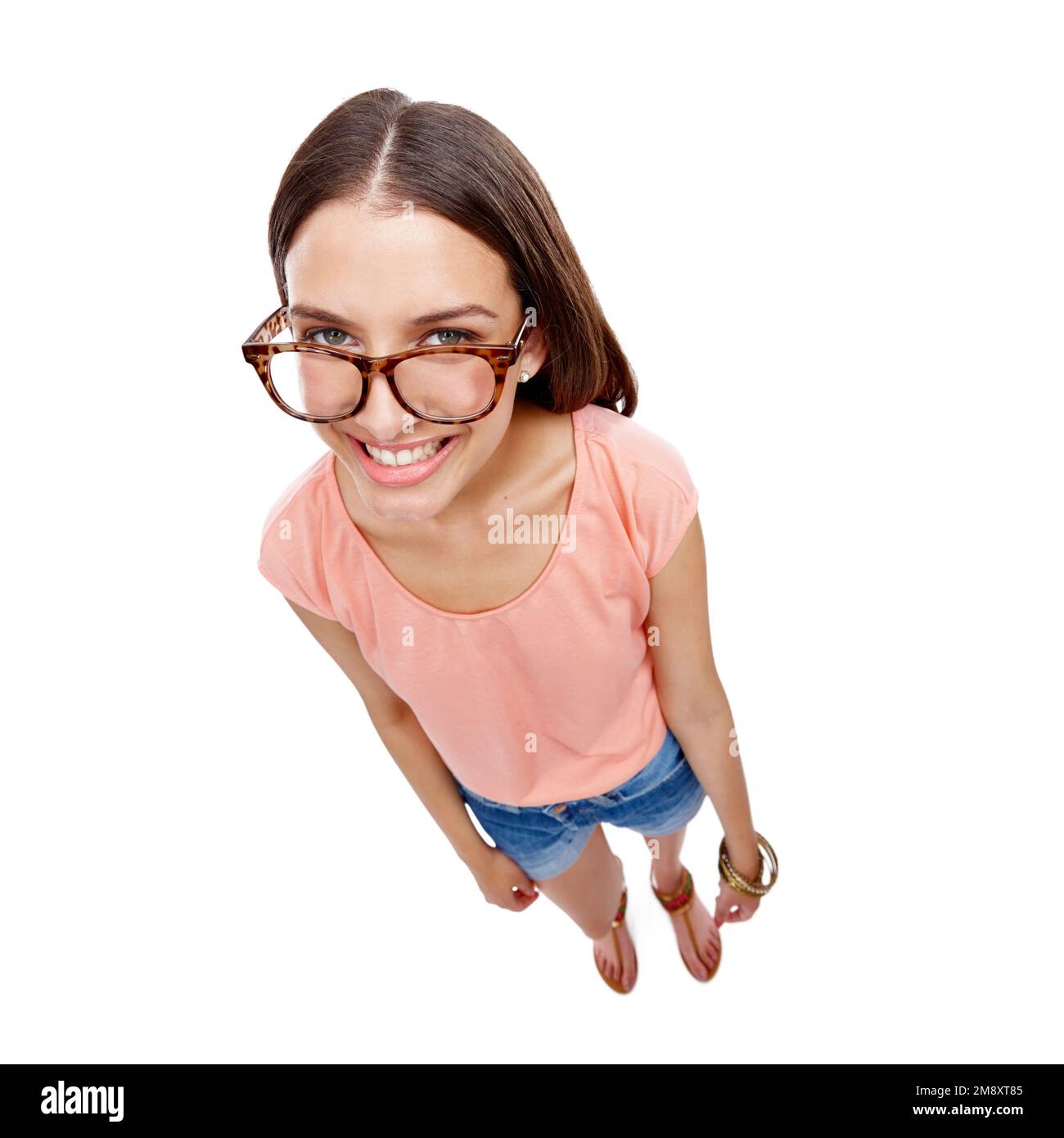 Woman, happy and portrait of a model with glasses, smile and casual fashion. White background, happiness and isolated young person looking up with Stock Photo