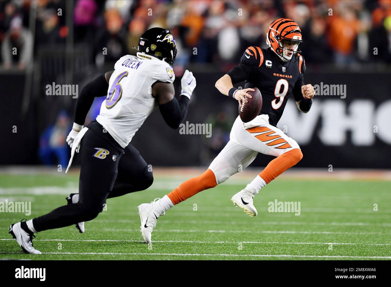 Cincinnati Bengals quarterback Joe Burrow (9) carries the ball against  Baltimore Ravens linebacker Patrick Queen (6) during the first half of an  NFL wild-card football game Sunday, Jan. 15, 2023, in Cincinnati. (