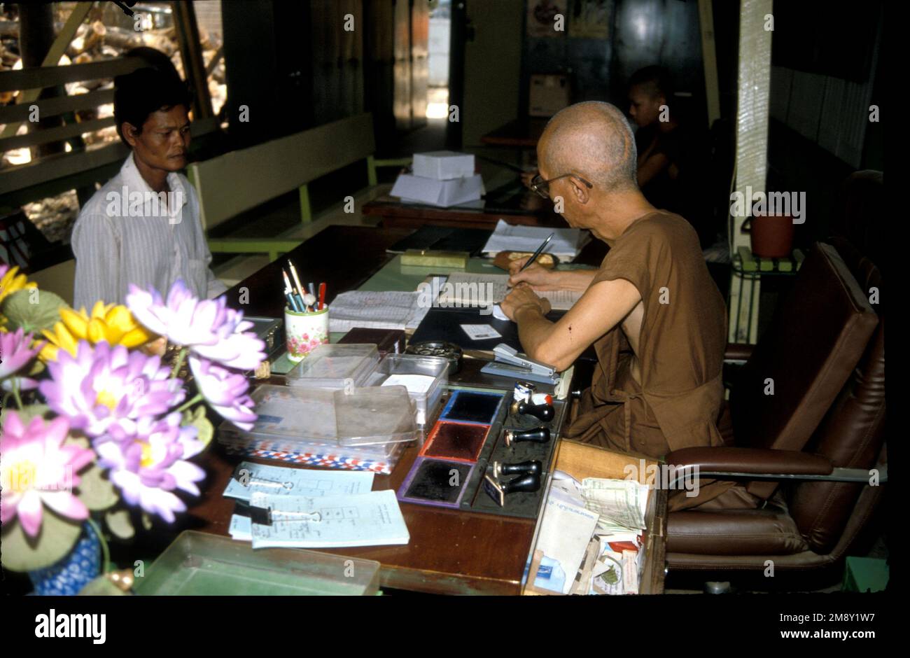 A monk registers a new inmate who has come to Wat Tham Krabok, drug rehabilitation monastery in Thailand, 1988 Stock Photo