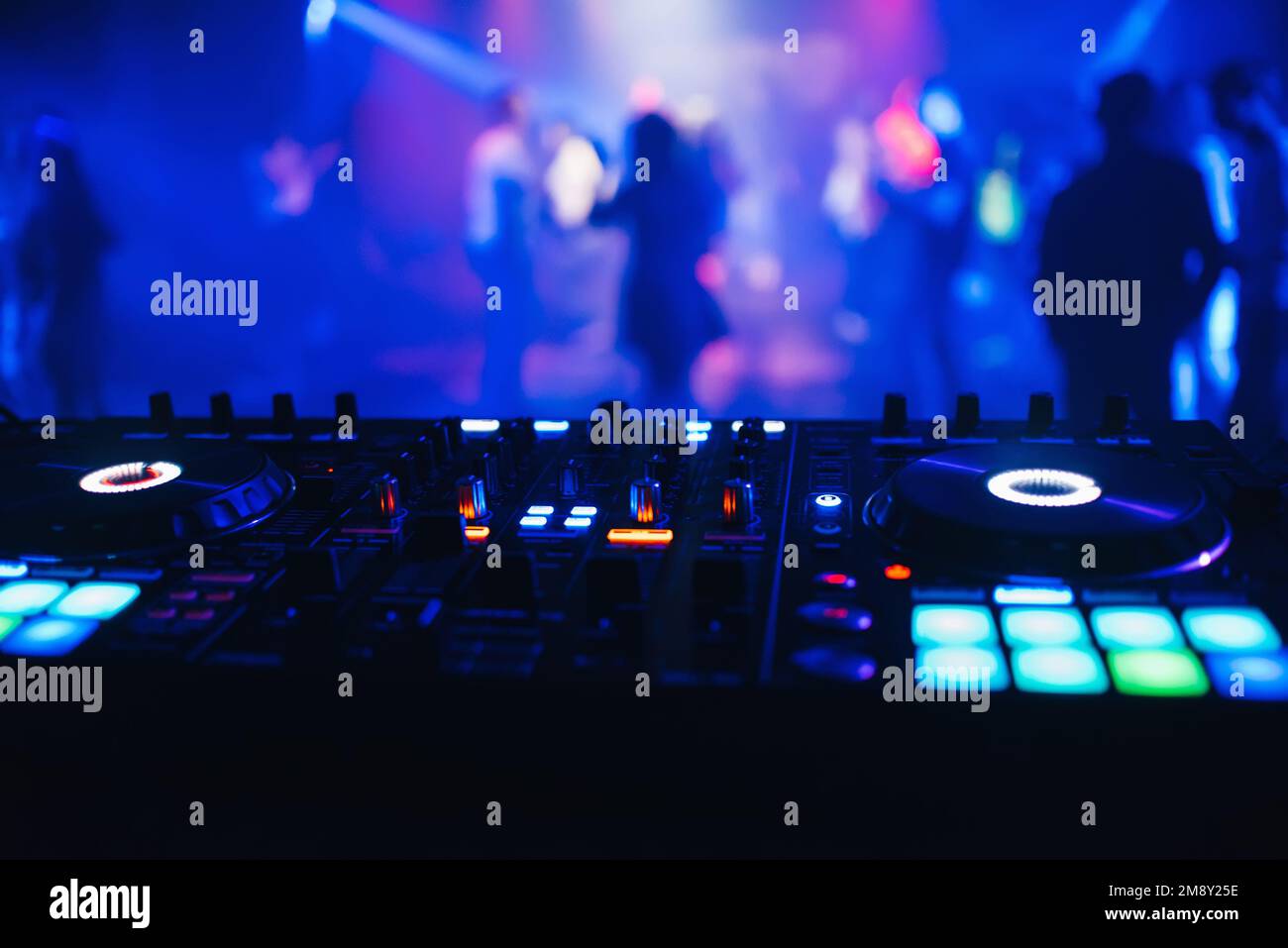DJ mixer on the table background the night club and dancing people Stock Photo Alamy
