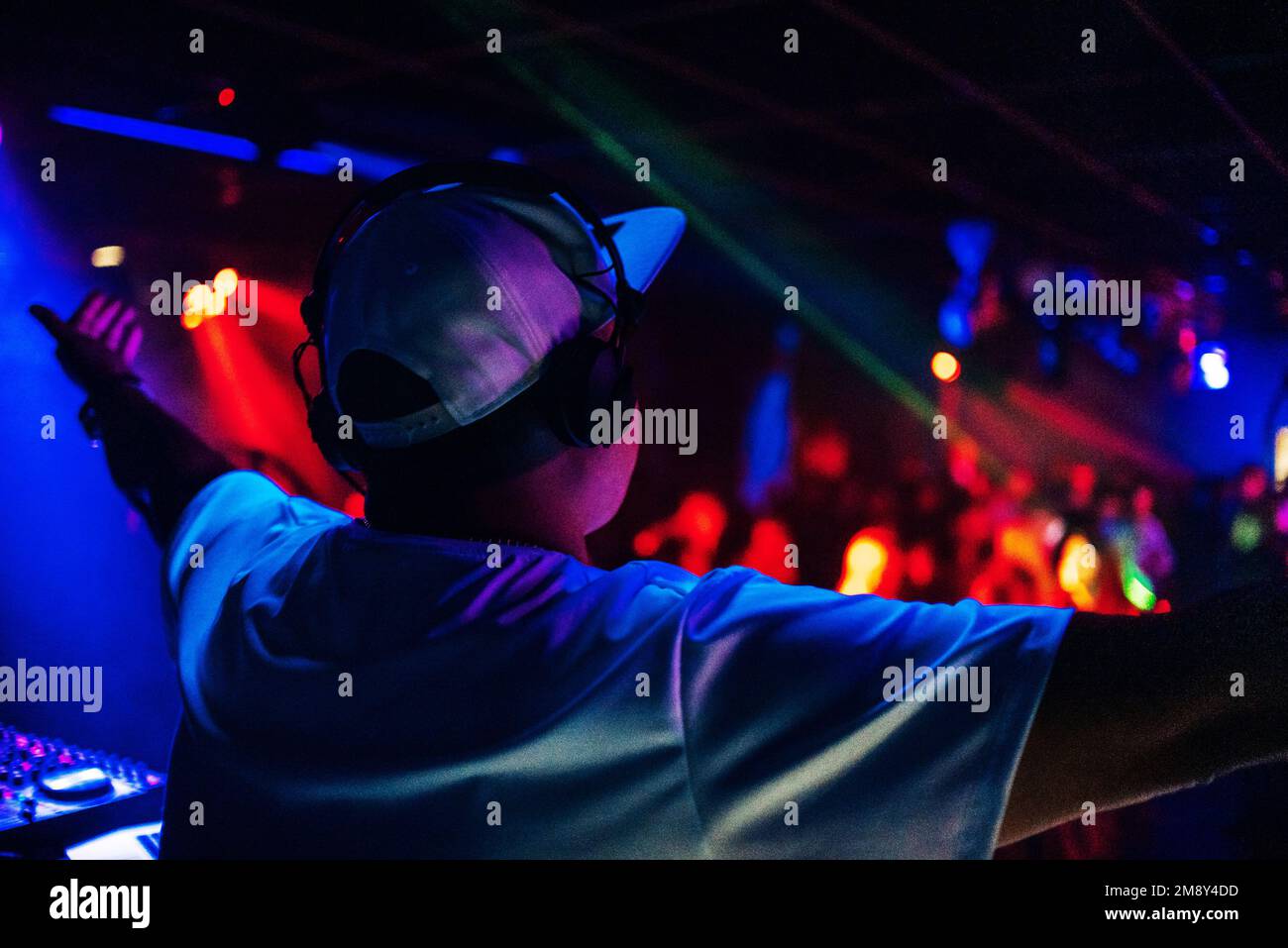 DJ from the back on the stage of a with headphones with grain