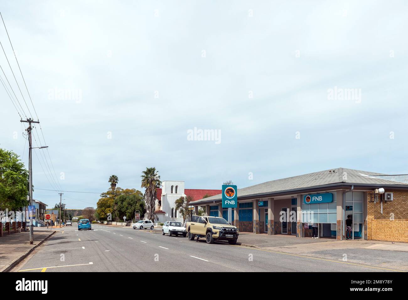 Heidelberg, South Africa - Sep 24, 2022: A street scene, with a bank building, the St Barnabas Anglican Church and vehicles, in Heidelberg in the West Stock Photo