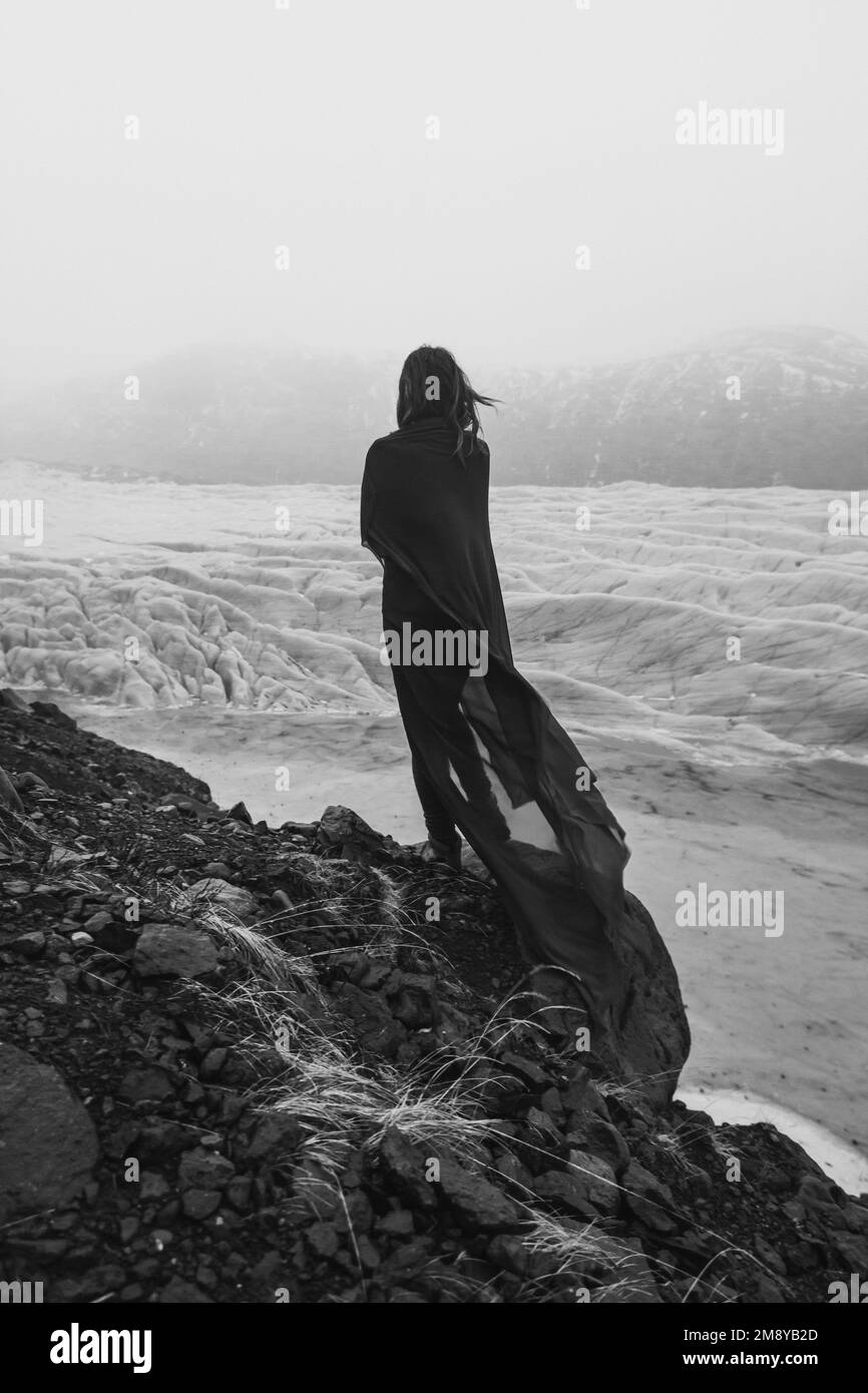 Lady wrapped with gentle fabric on cliff monochrome scenic photography Stock Photo