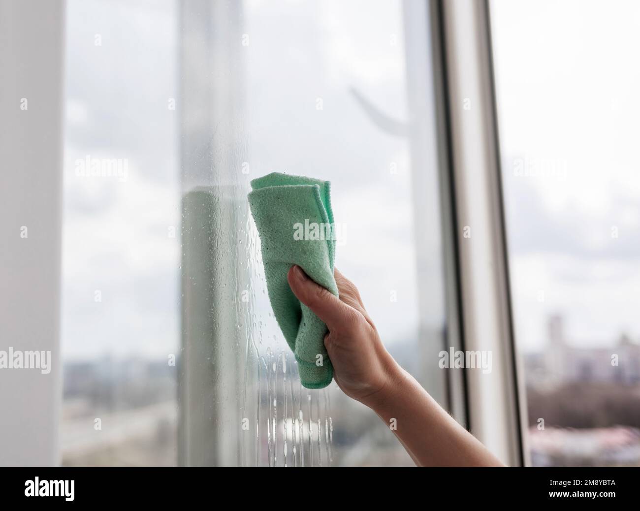 housekeeping concept - woman cleaning window with rag at home Stock ...