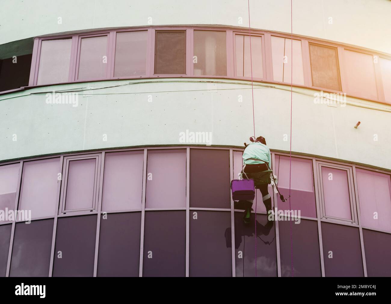 Window washer cleaning building facade. work at height. industrial