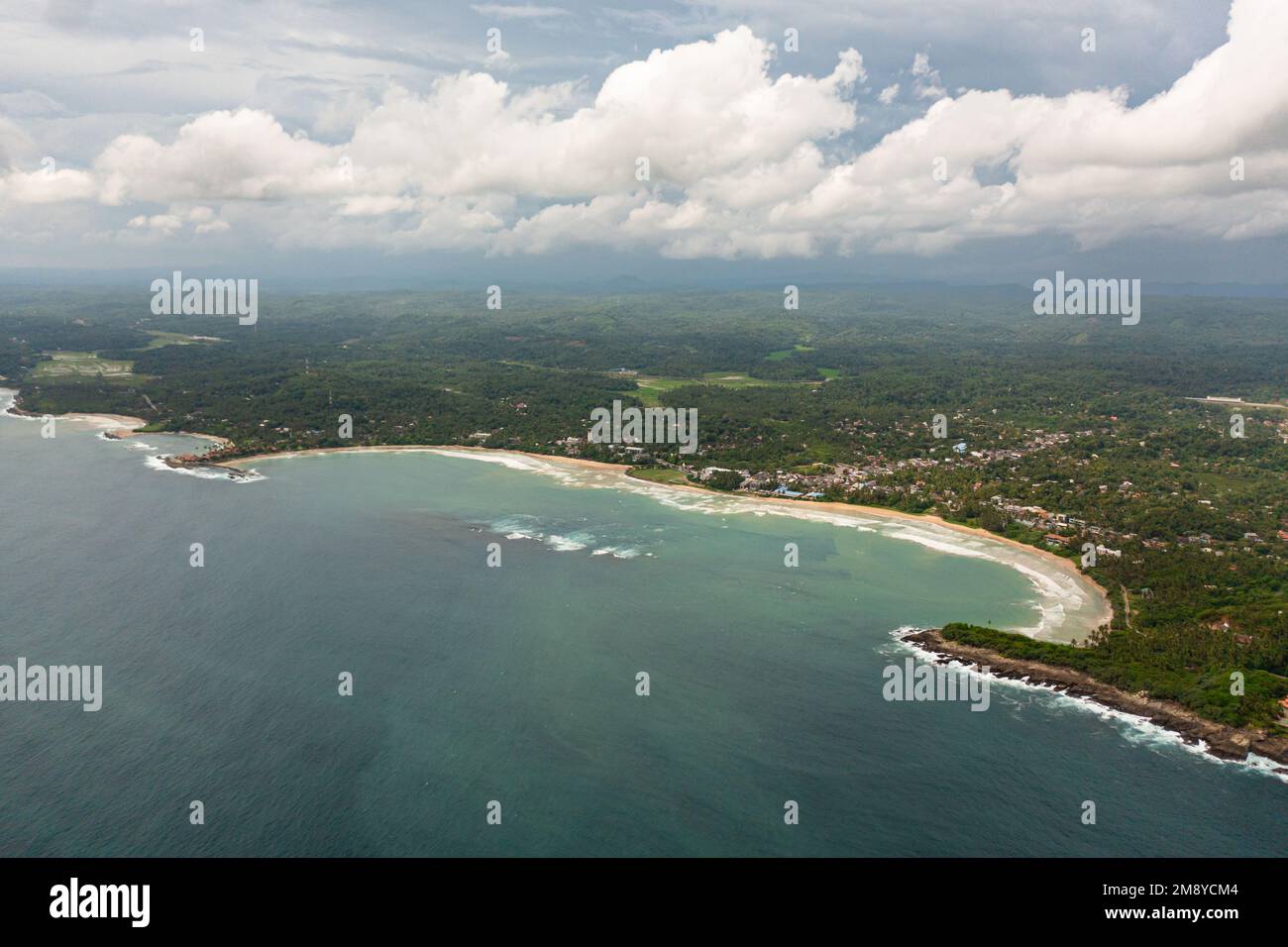 Aerial drone of coast with a beach and hotels among palm trees. Dickwella Beach, Sri Lanka. Stock Photo