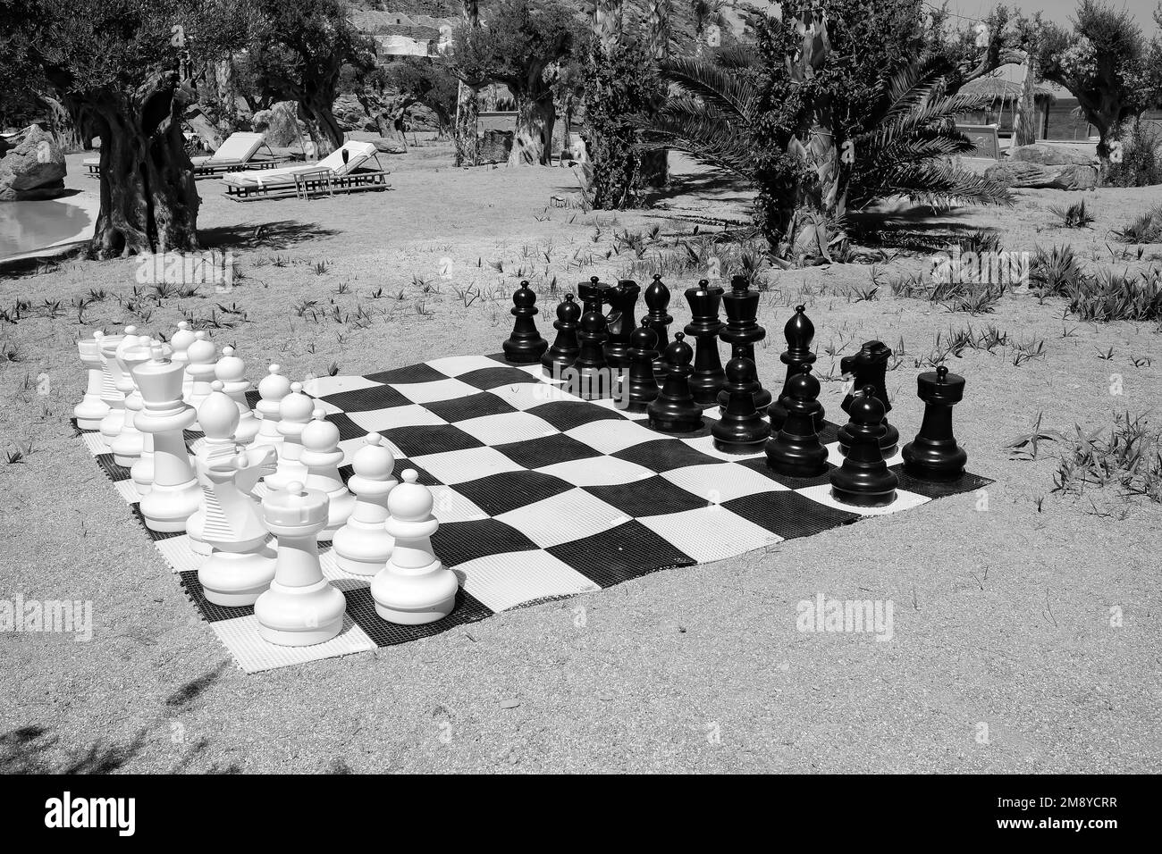 Ios, Greece - June 6, 2021 : View of a life size giant chessboard at the beach in Ios Greece in black and white Stock Photo