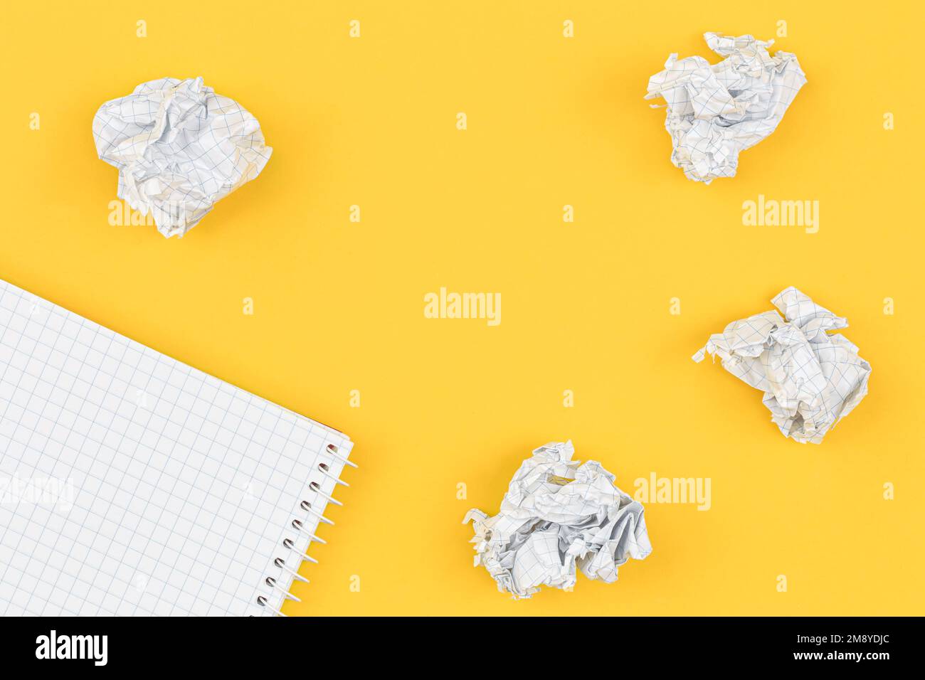 Empty notebook and crumpled paper balls, flat lay. Stock Photo
