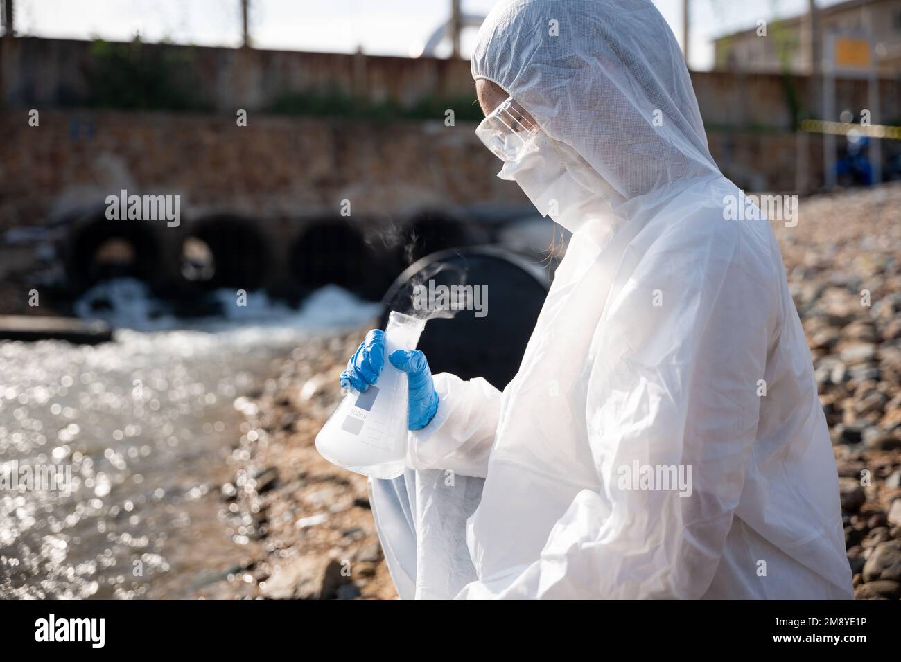 Ecologist sampling water toxic chemicals from river with test tube ...