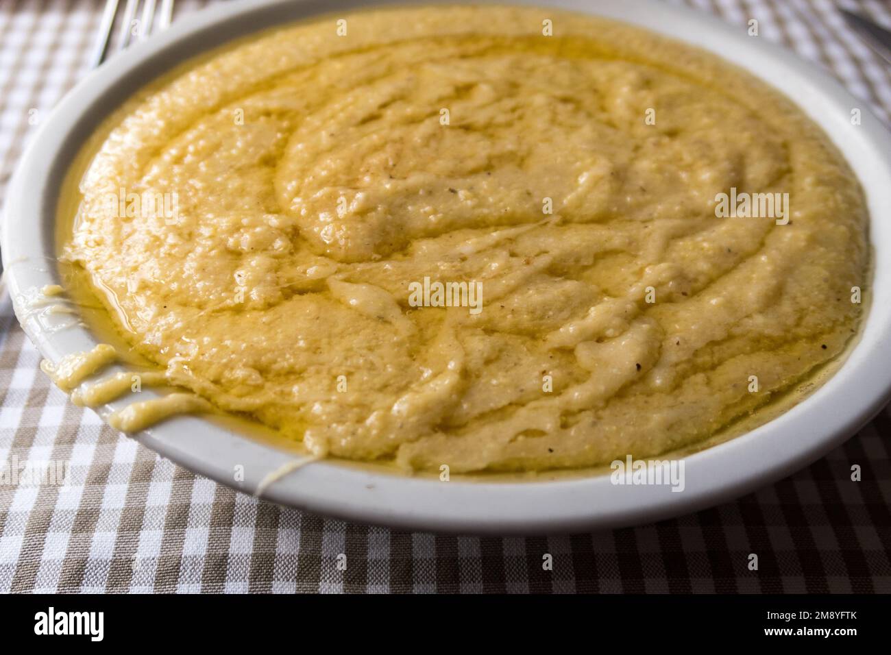 A closeup view of a portion of polenta concia, a traditional meal served in the alpine region