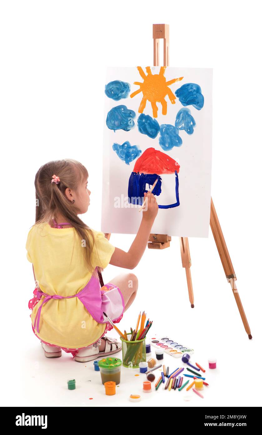 The child is drawing. Children's painting. Little girl draws the sun. The schoolboy does his homework in art. Arts and crafts for children. Paint on Stock Photo