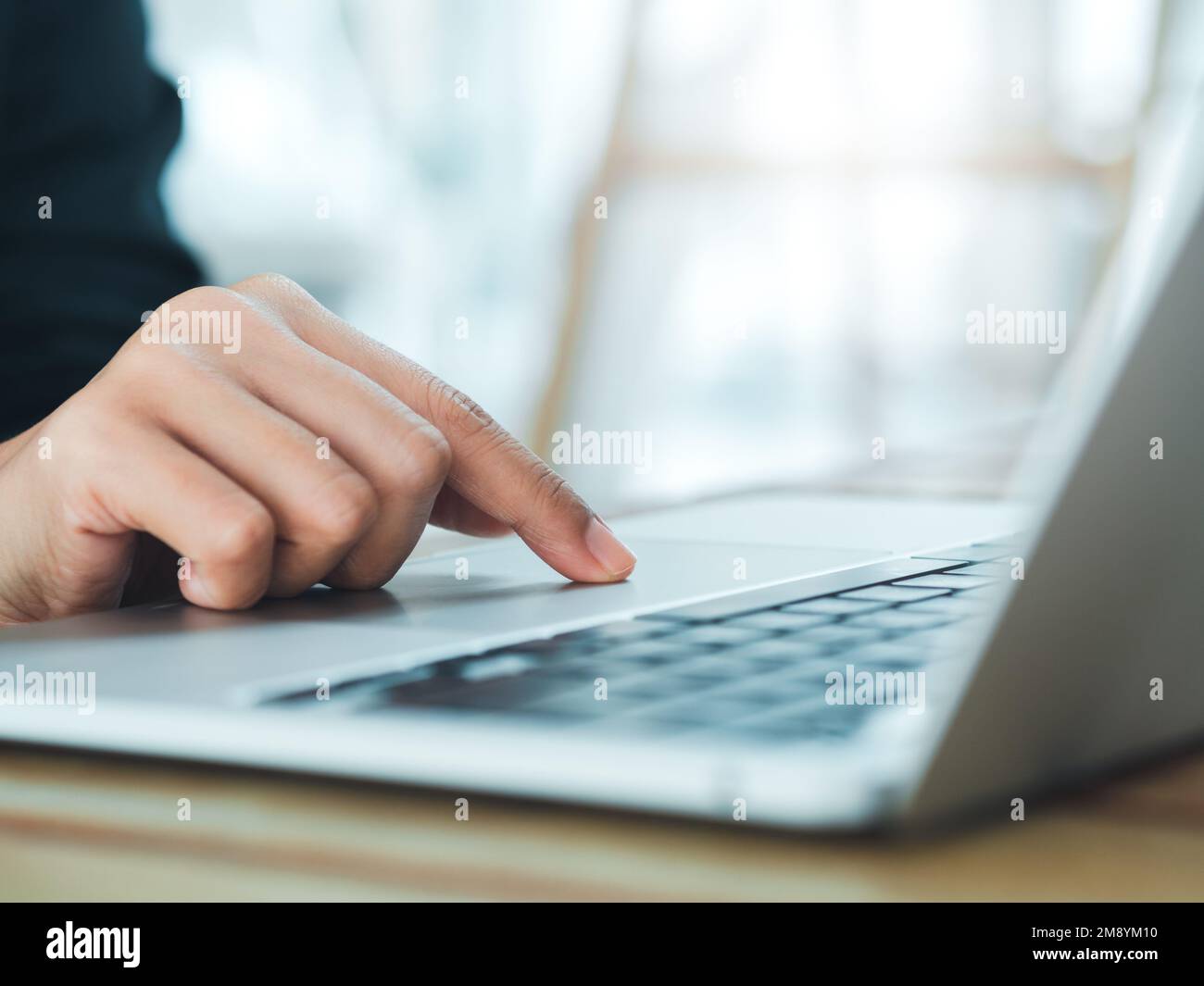 Close-up finger of business person in suit touch on touchpad on laptop computer. Working on notebook, business technology concept. Control your digita Stock Photo