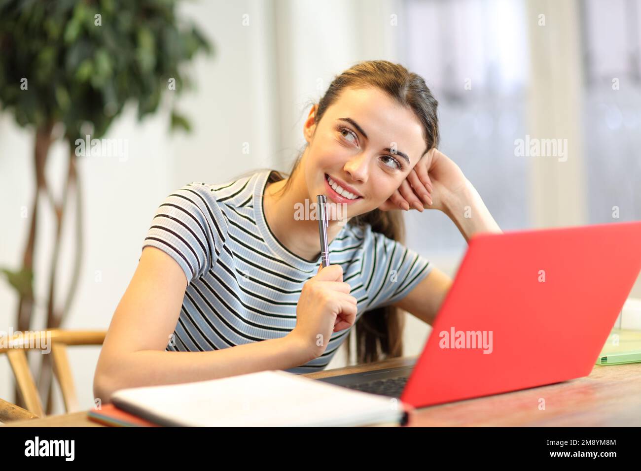 Student dreaming looking above with a laptop Stock Photo
