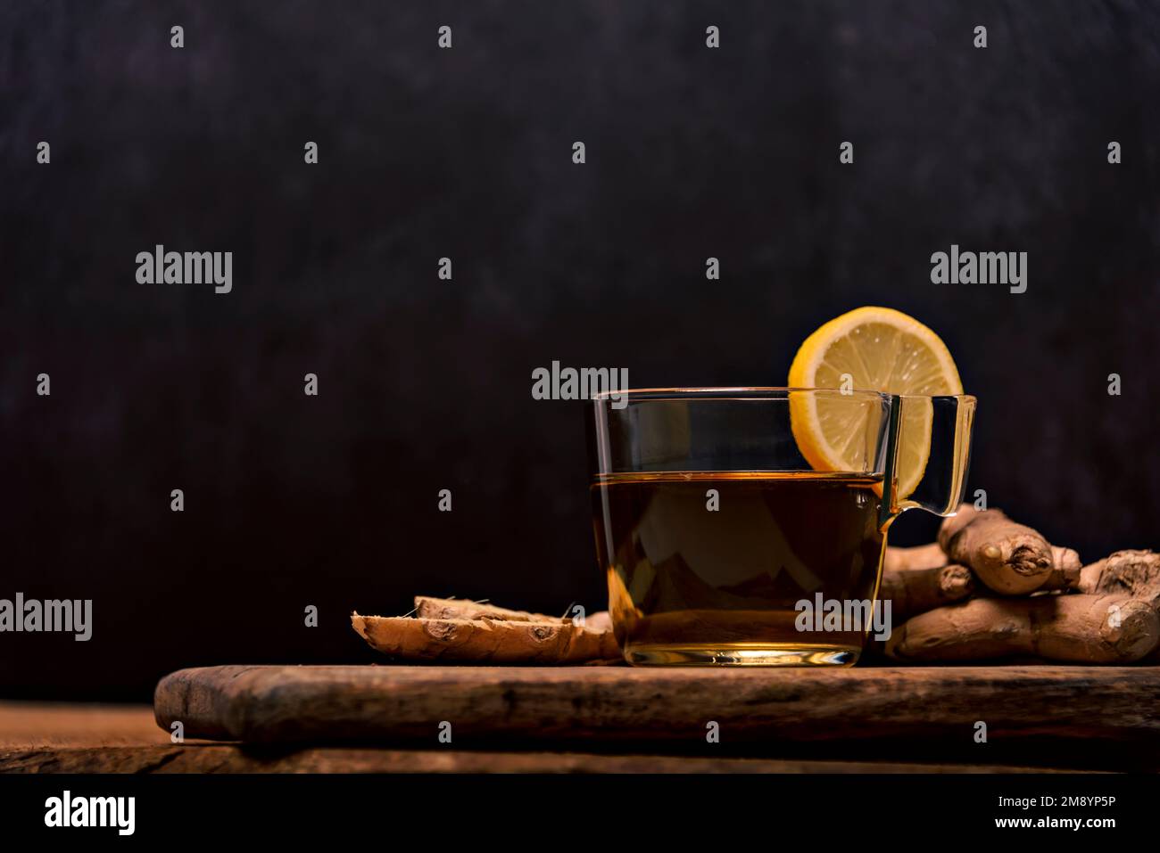 Cup of spiced tea with cinnamon sticks, anise star, lemon and jinger on